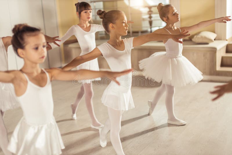 Sweet caucasian little ballerinas wearing white tutu perdorming dance together, ballet concept. Sweet caucasian little ballerinas wearing white tutu perdorming dance together, ballet concept