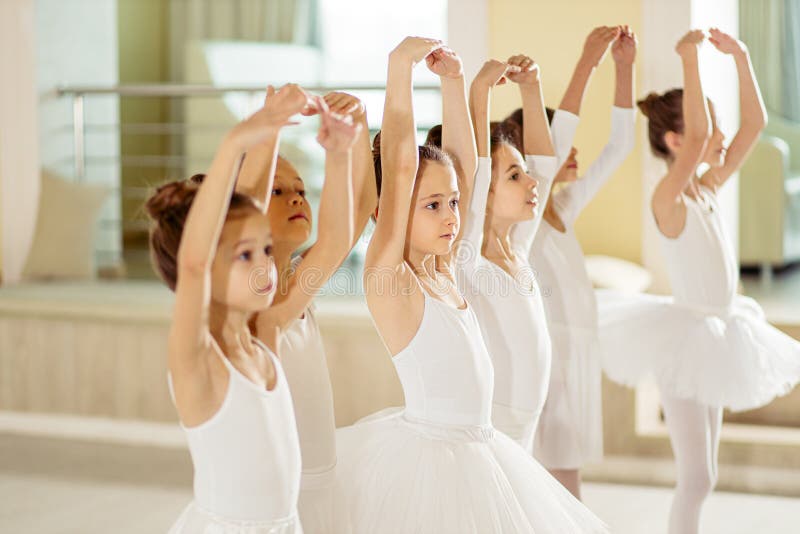 Sweet caucasian little ballerinas wearing white tutu perdorming dance together, ballet concept. Sweet caucasian little ballerinas wearing white tutu perdorming dance together, ballet concept