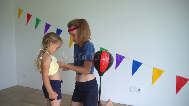 Niñas de familia felices madre e hija preparándose para el boxeo. movimiento de trucos