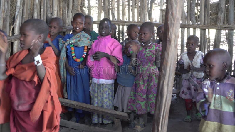 Niñas y niños de la tribu masai cantando en clase escolar en chot. niños africanos