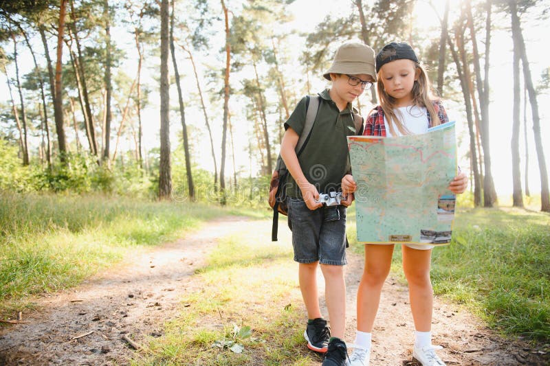 Niñito y niña van de excursión por el camino del bosque fotografía de archivo libre de regalías