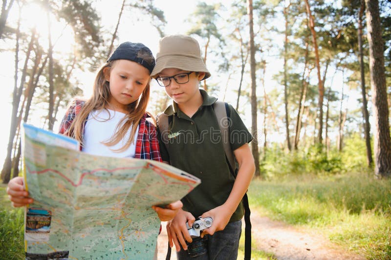 Niñito y niña van de excursión por el camino del bosque imagen de archivo