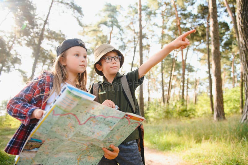 Niñito y niña van de excursión por el camino del bosque fotografía de archivo libre de regalías