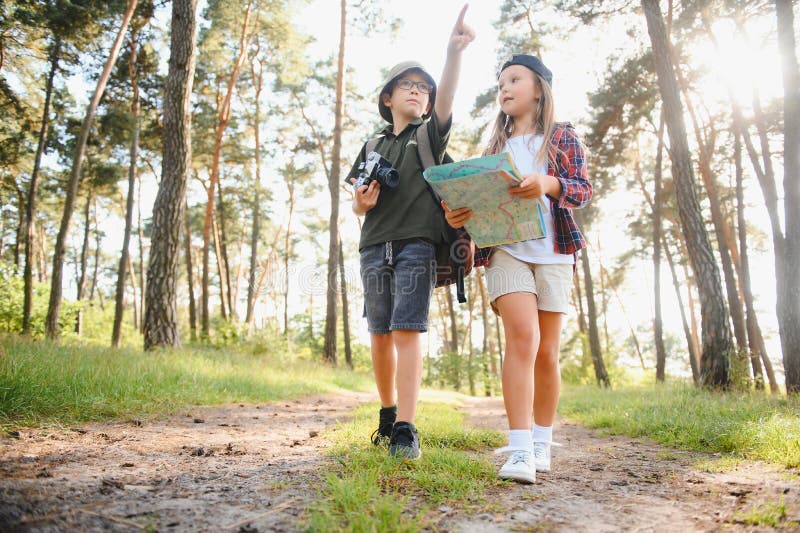 Niñito y niña van de excursión por el camino del bosque foto de archivo libre de regalías