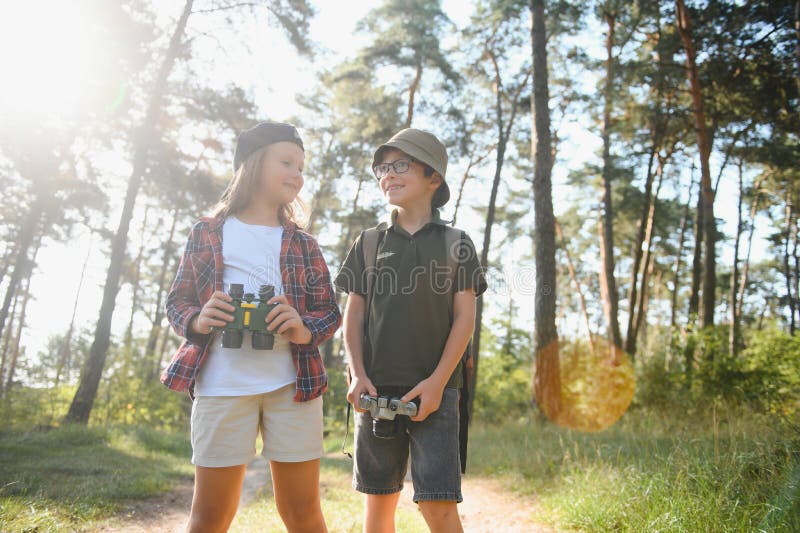 Niñito y niña van de excursión por el camino del bosque foto de archivo libre de regalías