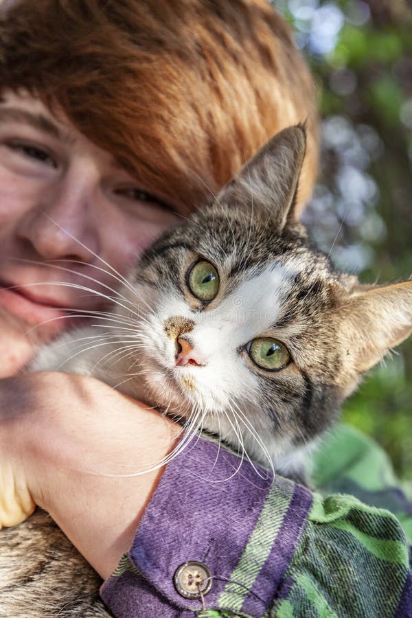 Niño abrazando a su lindo gato pequeño fotos de archivo