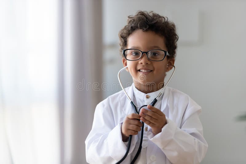 Niño afro-norteamericano desviado del retrato principal del disparo jugando al médico imagen de archivo