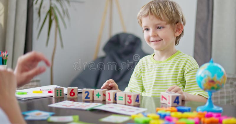 Niño aprendiendo matemáticas con bloques de madera almacen de video