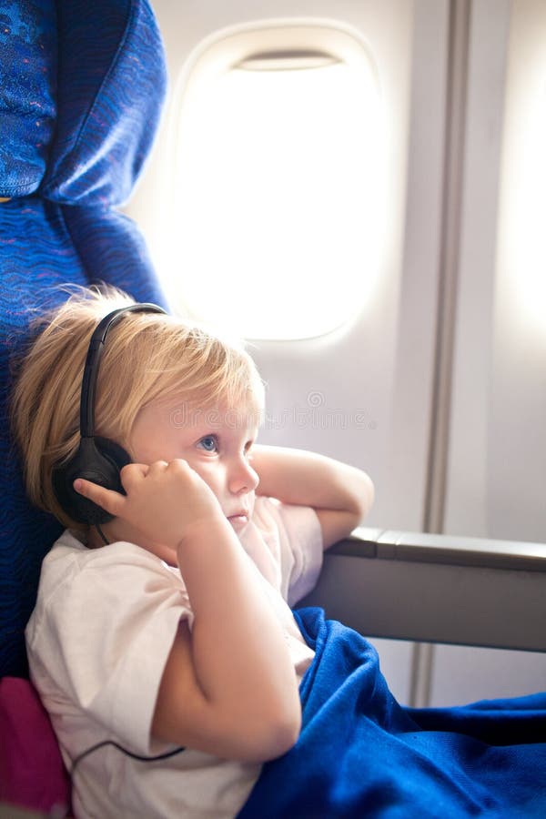 Niño con los auriculares en el avión imágenes de archivo libres de regalías Niño con los auriculares en el avión imágenes de archivo libres de regalías