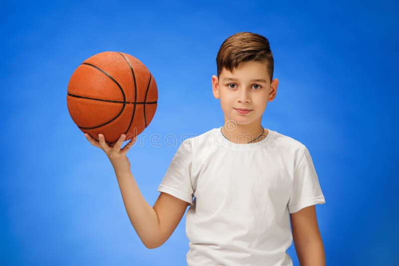 Niño de 11 años adorable del muchacho con la bola del baloncesto imagen de archivo libre de regalías Niño de 11 años adorable del muchacho con la bola del baloncesto imagen de archivo libre de regalías