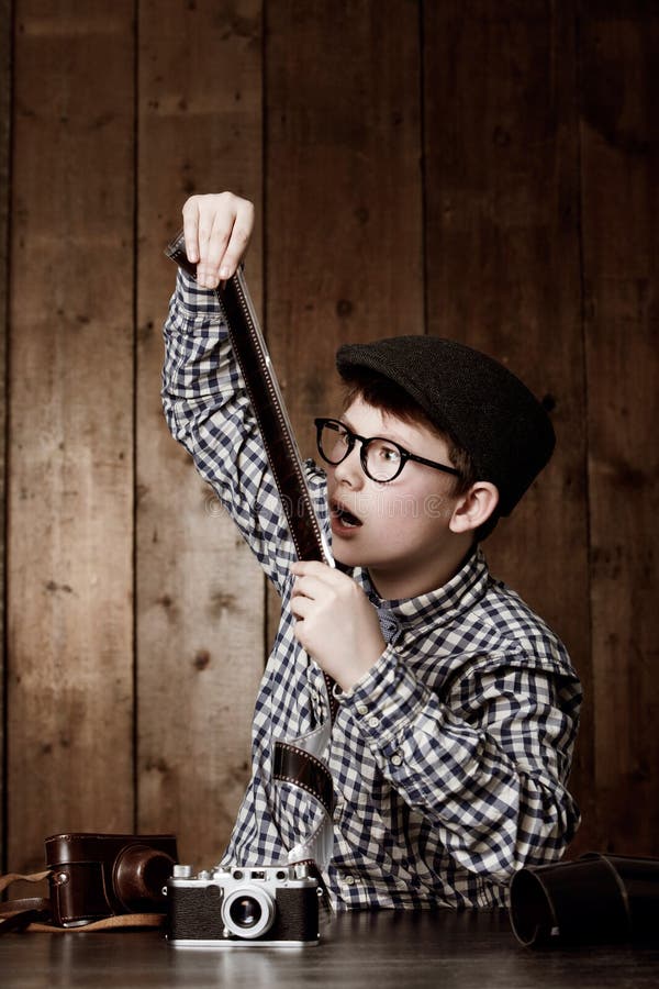 Niño de gafas y fotografía con película retro con sorprendentes imágenes creativas y vintage en foto-negativos. joven fotos de archivo libres de regalías