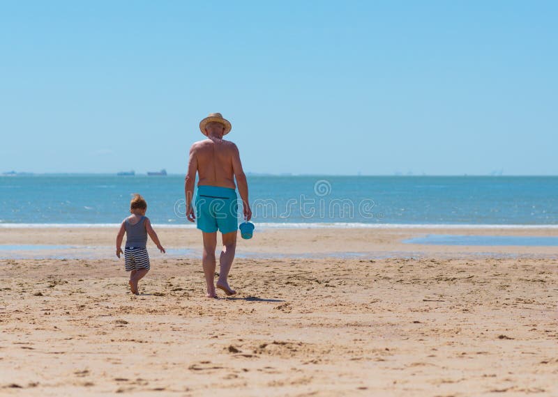 Niño del niño pequeño con el abuelo en la playa imágenes de archivo libres de regalías Niño del niño pequeño con el abuelo en la playa imágenes de archivo libres de regalías