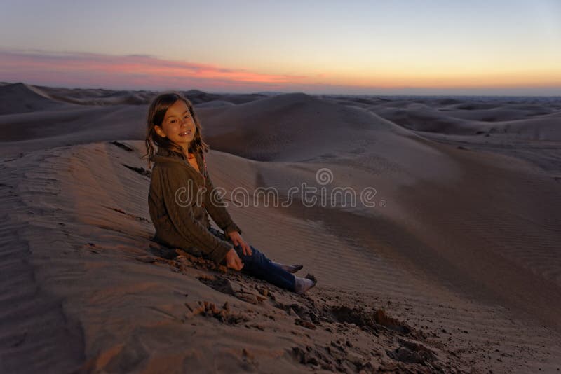 Niño en desierto en la puesta del sol imagen de archivo libre de regalías Niño en desierto en la puesta del sol imagen de archivo libre de regalías