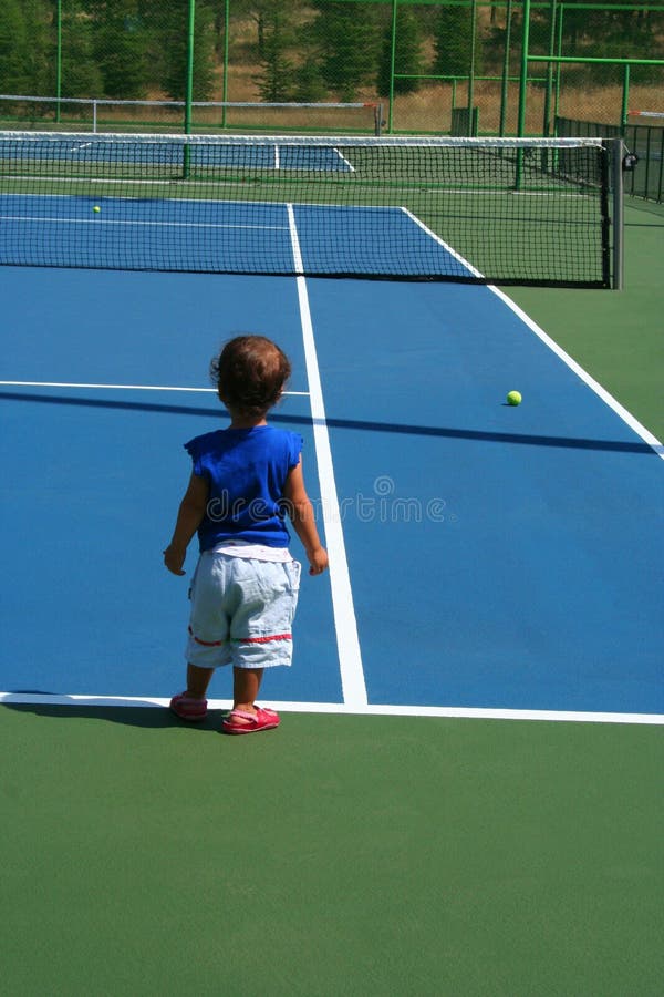 Niño en el cort del tenis