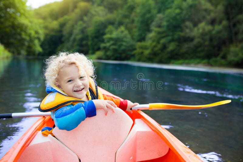 Niño en el kajak Niños en la canoa El acampar del verano imagen de archivo libre de regalías Niño en el kajak Niños en la canoa El acampar del verano imagen de archivo libre de regalías