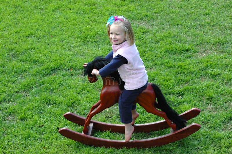Niño en oscilar-caballo fotografía de archivo libre de regalías Niño en oscilar-caballo fotografía de archivo libre de regalías