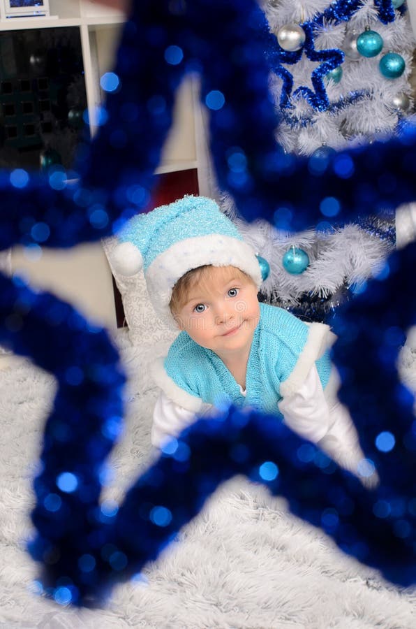 Niño en traje de la Navidad a través de la estrella decorativa imágenes de archivo libres de regalías