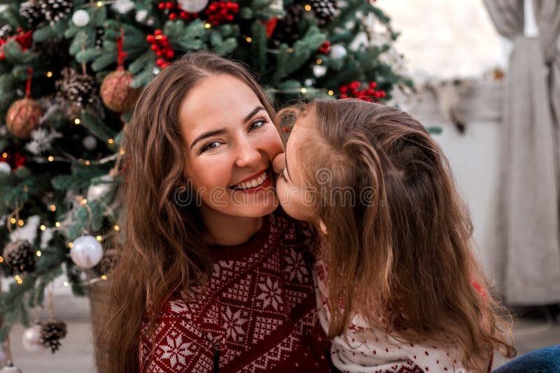 Niño feliz que besa a su madre cerca de abeto imágenes de archivo libres de regalías Niño feliz que besa a su madre cerca de abeto imágenes de archivo libres de regalías