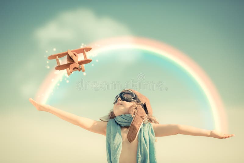Niño feliz que juega con el aeroplano del juguete