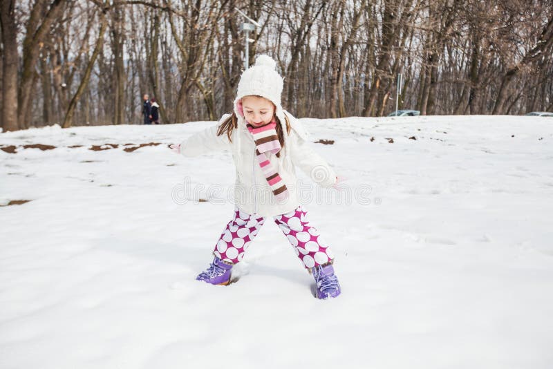 Niño feliz que juega en nieve en el parque en el día de invierno imagen de archivo libre de regalías Niño feliz que juega en nieve en el parque en el día de invierno imagen de archivo libre de regalías