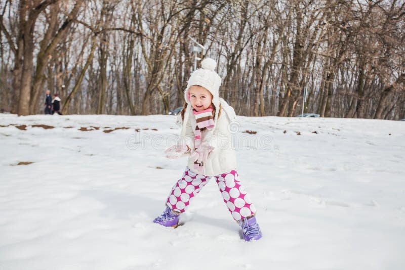 Niño feliz que juega en nieve en el parque en el día de invierno imagen de archivo Niño feliz que juega en nieve en el parque en el día de invierno imagen de archivo