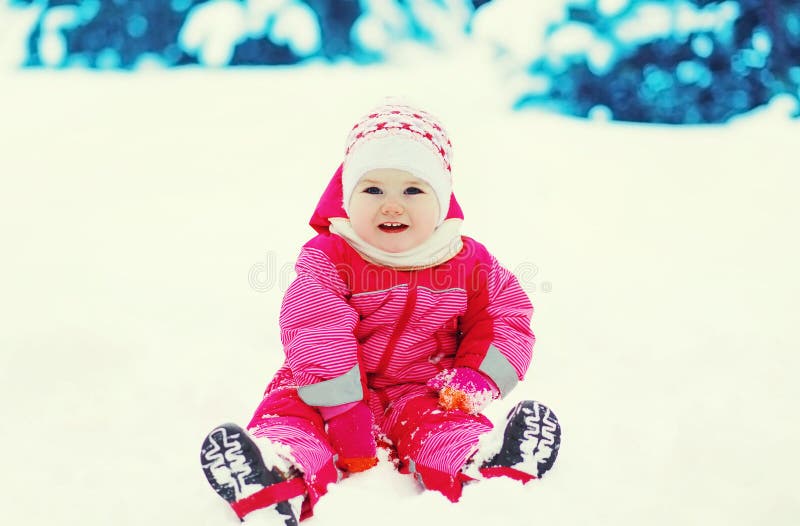 Niño feliz que juega en nieve en día de invierno fotografía de archivo Niño feliz que juega en nieve en día de invierno fotografía de archivo