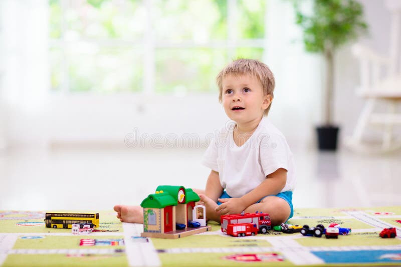 Niño jugando coches de juguete. niño con juguetes. niño y coche fotografía de archivo libre de regalías