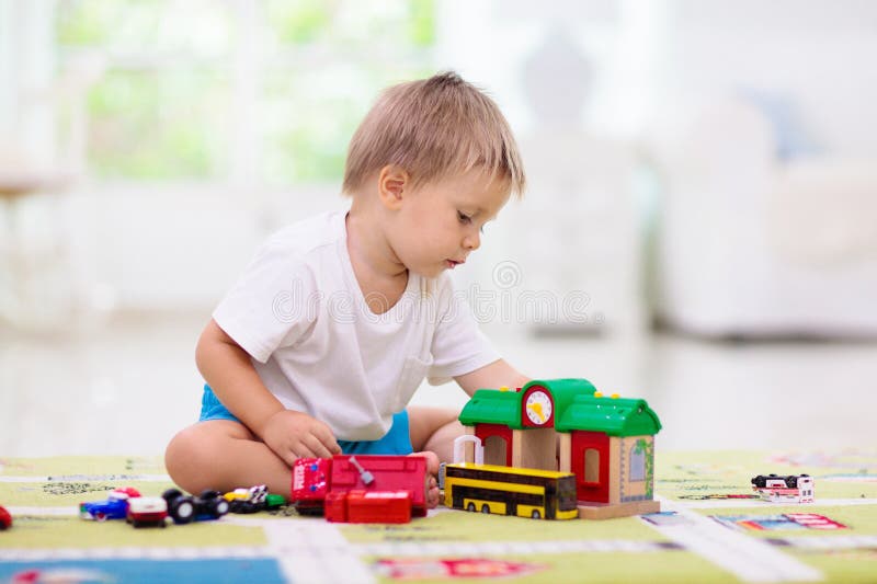 Niño jugando coches de juguete. niño con juguetes. niño y coche imagenes de archivo