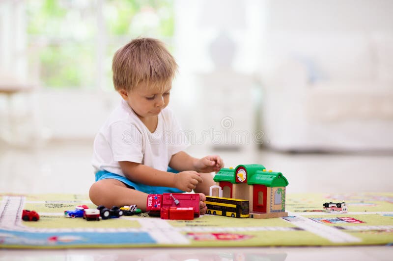 Niño jugando coches de juguete. niño con juguetes. niño y coche fotografía de archivo
