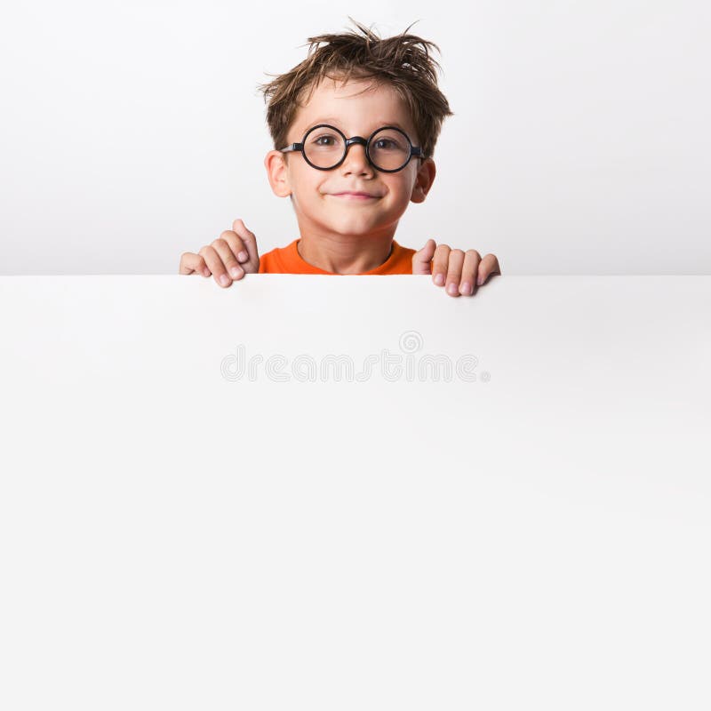 Photo of positive schoolkid behind partition looking at camera with smile. Photo of positive schoolkid behind partition looking at camera with smile