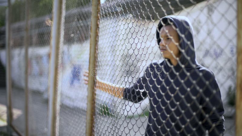 Niño migratorio separado de la familia, muchacho afroamericano detrás de la cerca, detenida imágenes de archivo libres de regalías Niño migratorio separado de la familia, muchacho afroamericano detrás de la cerca, detenida imágenes de archivo libres de regalías