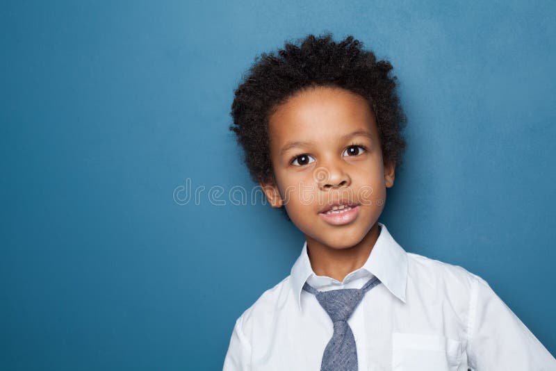 Little black child boy smiling and looking up on blue background. Little black child boy smiling and looking up on blue background.