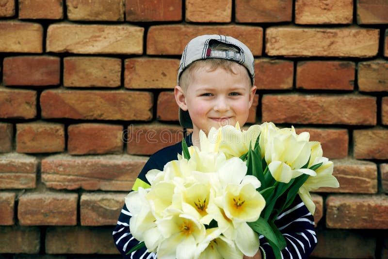 Niño pequeño adorable con un ramo de tulipanes fotos de archivo libres de regalías Niño pequeño adorable con un ramo de tulipanes fotos de archivo libres de regalías
