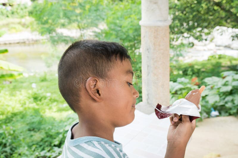 niño pequeño asiático que come el helado imagenes de archivo niño pequeño asiático que come el helado imagenes de archivo