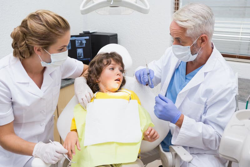 Terrified little boy looking at needle in dentists chair at the dental clinic. Terrified little boy looking at needle in dentists chair at the dental clinic