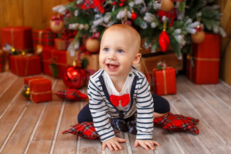 Niño pequeño cerca del árbol de navidad con las cajas de regalo fotos de archivo Niño pequeño cerca del árbol de navidad con las cajas de regalo fotos de archivo
