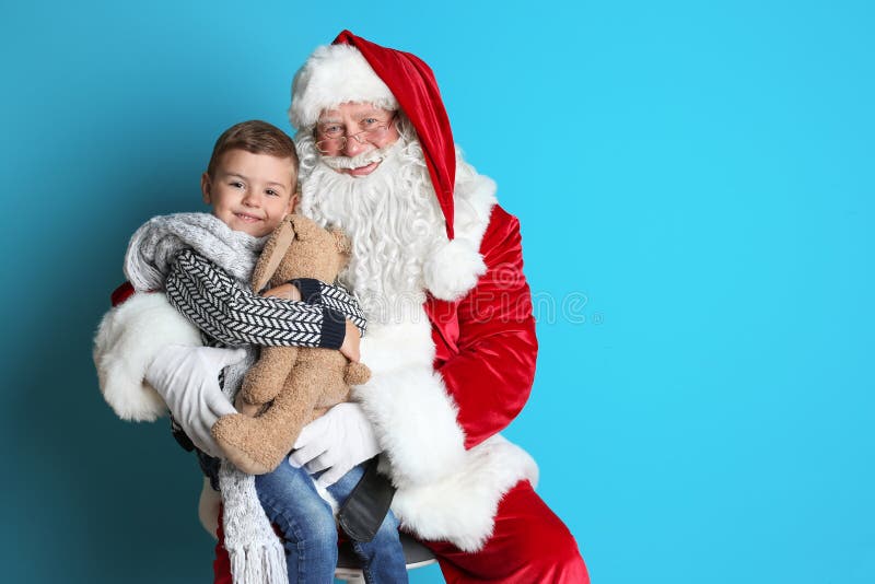 Niño pequeño con el conejito del juguete que se sienta en revestimiento auténtico del ` de Santa Claus foto de archivo Niño pequeño con el conejito del juguete que se sienta en revestimiento auténtico del ` de Santa Claus foto de archivo