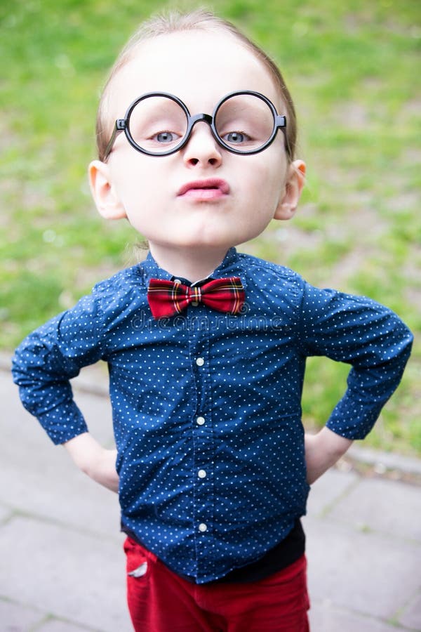 Niño pequeño con la cabeza grande y los vidrios que parecen arrogantes stock de ilustración Niño pequeño con la cabeza grande y los vidrios que parecen arrogantes stock de ilustración