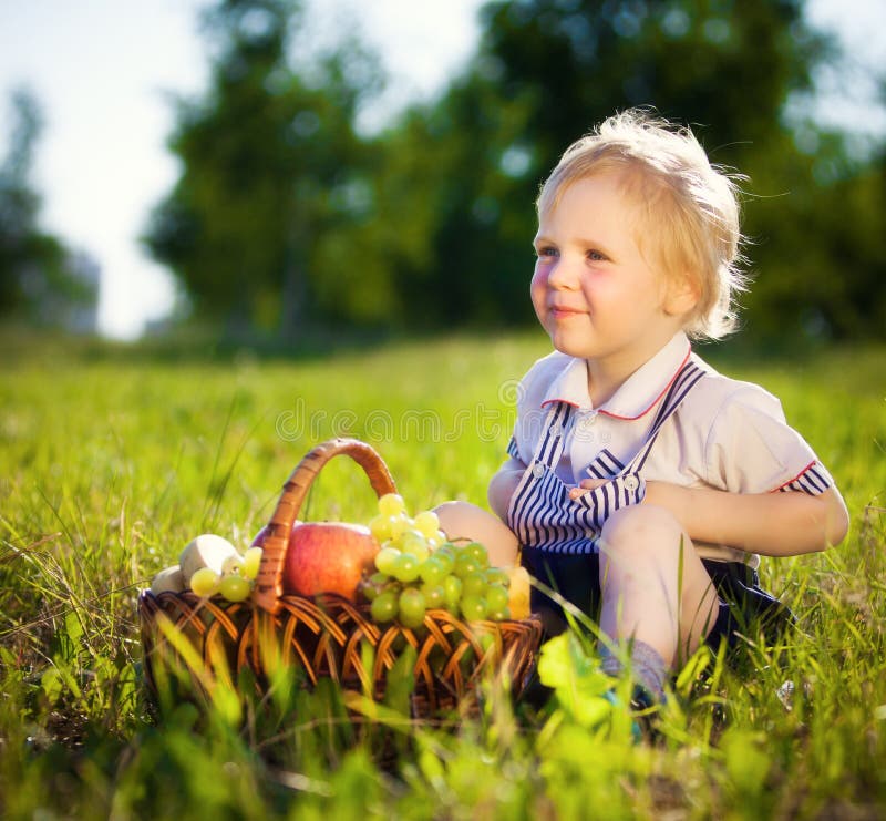 Niño pequeño con una cesta de fruta imagen de archivo Niño pequeño con una cesta de fruta imagen de archivo