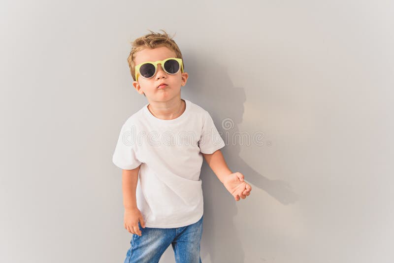 Niño pequeño en las gafas de sol que presentan en estudio foto de archivo libre de regalías Niño pequeño en las gafas de sol que presentan en estudio foto de archivo libre de regalías
