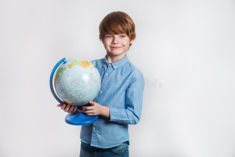 Niño pequeño feliz que sostiene el globo De nuevo a escuela y a tiempo feliz imagen de archivo Niño pequeño feliz que sostiene el globo De nuevo a escuela y a tiempo feliz imagen de archivo