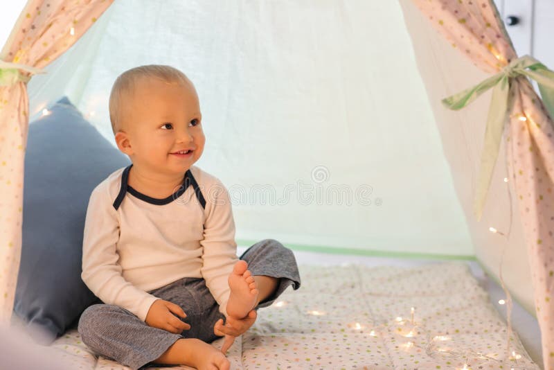 Niño pequeño lindo que descansa en tienda del juego fotografía de archivo libre de regalías Niño pequeño lindo que descansa en tienda del juego fotografía de archivo libre de regalías