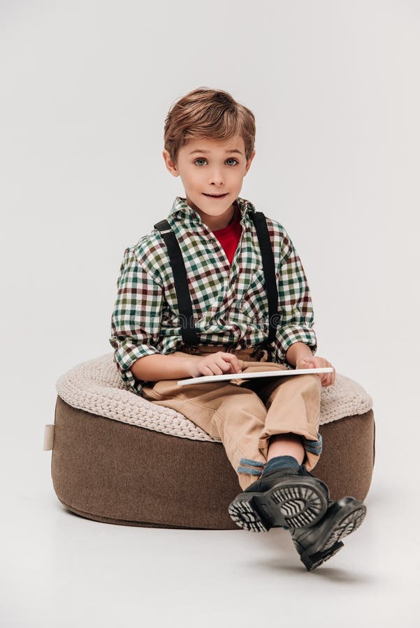 niño pequeño lindo que usa la tableta digital y sonriendo en la cámara fotos de archivo libres de regalías niño pequeño lindo que usa la tableta digital y sonriendo en la cámara fotos de archivo libres de regalías