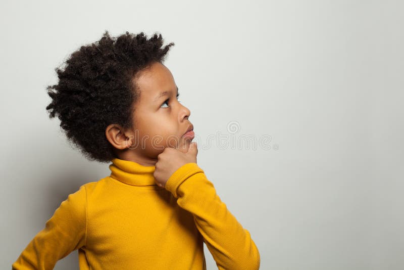 Small black kid boy thinking and looking up on white background. Small black kid boy thinking and looking up on white background.