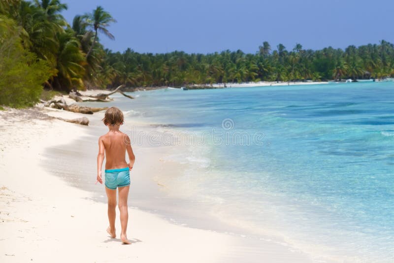 Niño pequeño que camina en la playa tropical fotografía de archivo Niño pequeño que camina en la playa tropical fotografía de archivo
