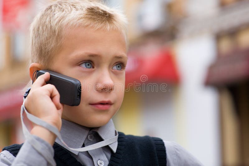 Niño pequeño que habla en un teléfono celular foto de archivo Niño pequeño que habla en un teléfono celular foto de archivo