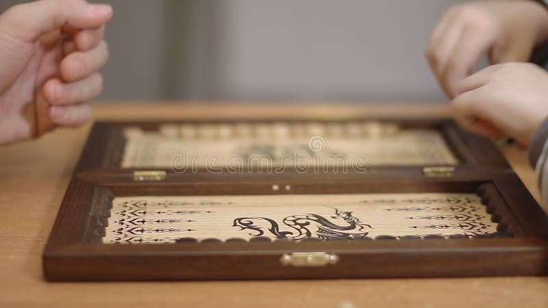 Niño pequeño que juega a backgammon con adulto