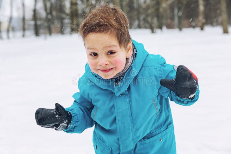 Niño pequeño que juega en la nieve y la risa fotos de archivo libres de regalías Niño pequeño que juega en la nieve y la risa fotos de archivo libres de regalías