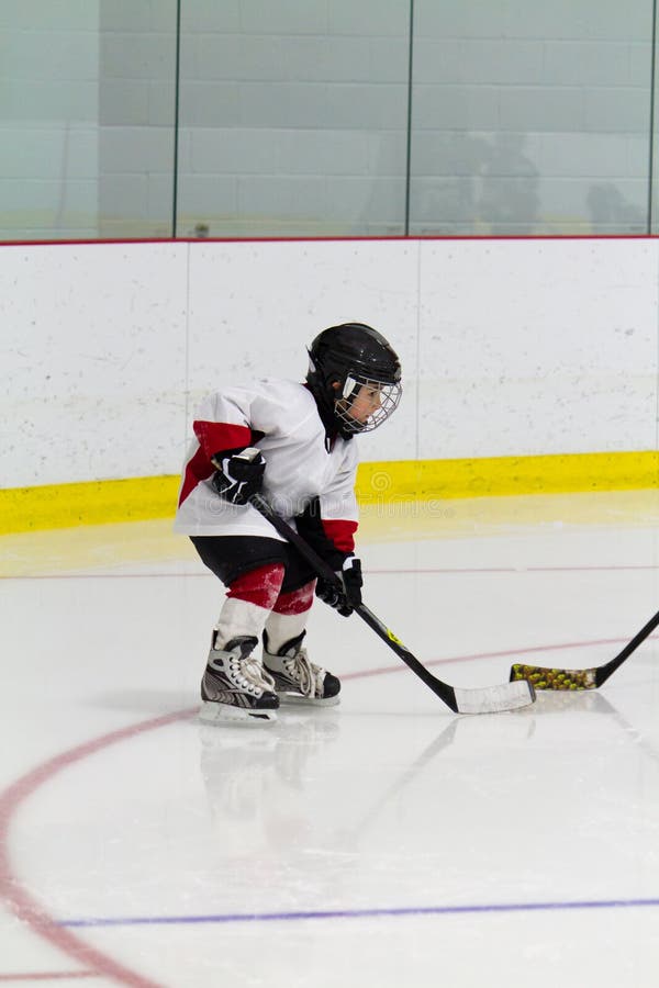 Niño pequeño que juega a hockey sobre hielo fotografía de archivo Niño pequeño que juega a hockey sobre hielo fotografía de archivo