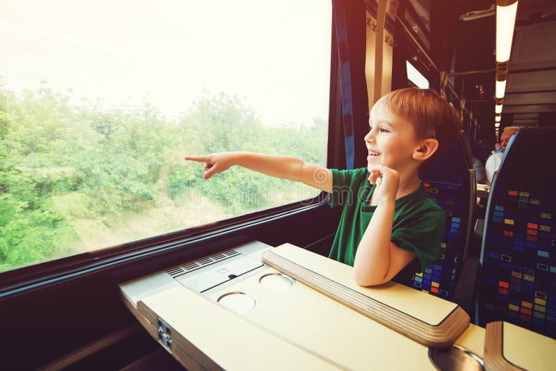 Niño pequeño que mira hacia fuera la ventana del tren Niño que señala afuera de ventana del tren Vacaciones de familia y el viaja fotos de archivo libres de regalías Niño pequeño que mira hacia fuera la ventana del tren Niño que señala afuera de ventana del tren Vacaciones de familia y el viaja fotos de archivo libres de regalías